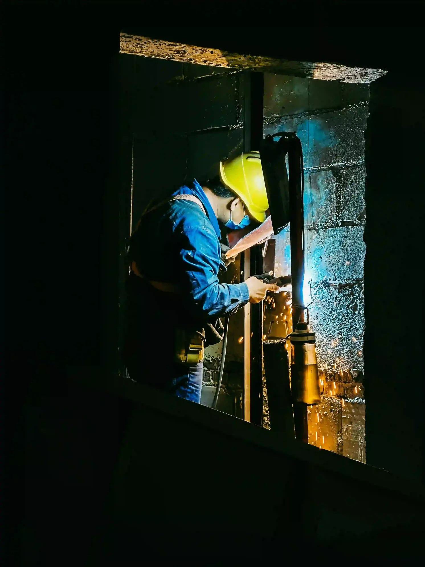 Soldador certificado trabajando en proyecto industrial con equipo de protección completo