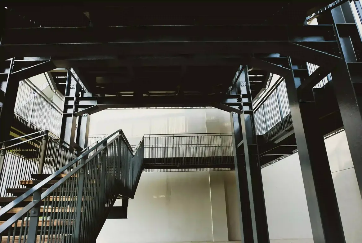 Escalera metálica industrial con barandas de seguridad certificadas
